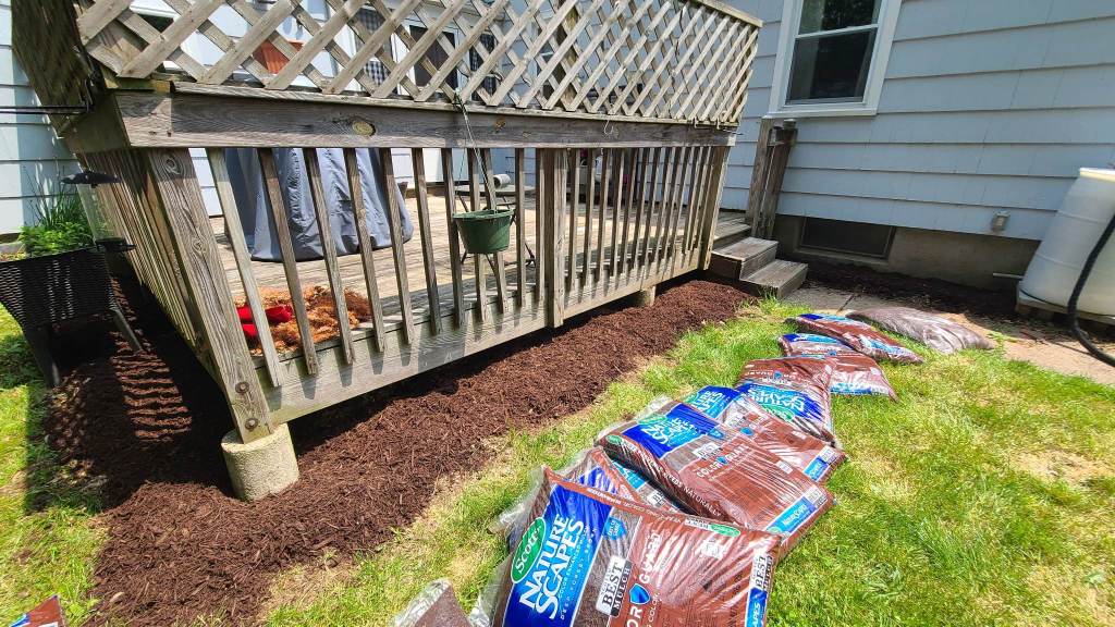 Mulch bags in front of a deck.